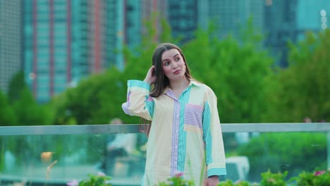 beautiful-caucasian-girl-scratching-head-and-thinking,-Daylight,-outside-in-chicago-with-skyscrapers-in-background-and-green-bushes-in-foregrround