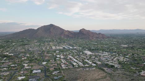 Aerial-shot-of-townscape-of-Paradise-Valley-flying-over-Mummy-Mountain-in-Arizona,-USA