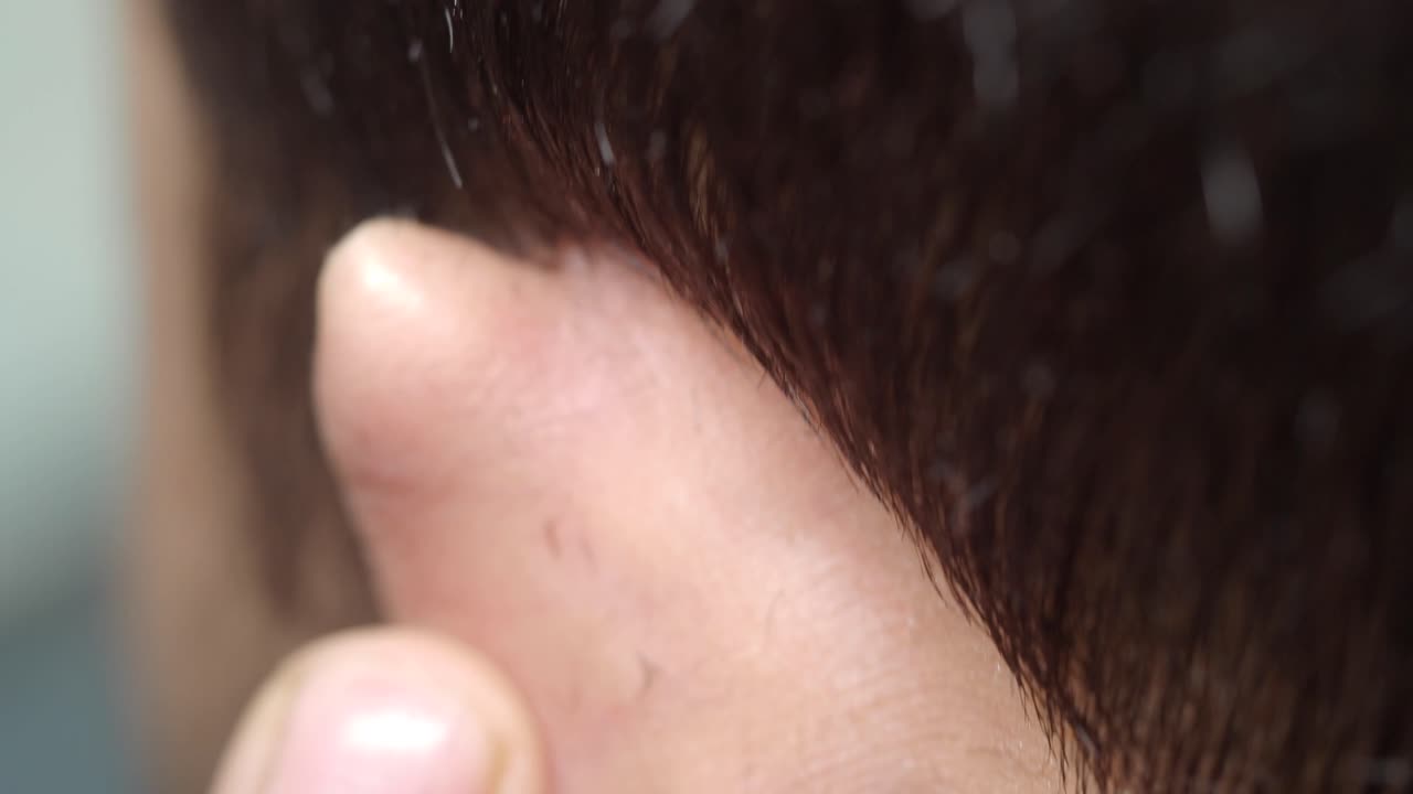 Close-up of a Man's Hair being Cut by a Barber