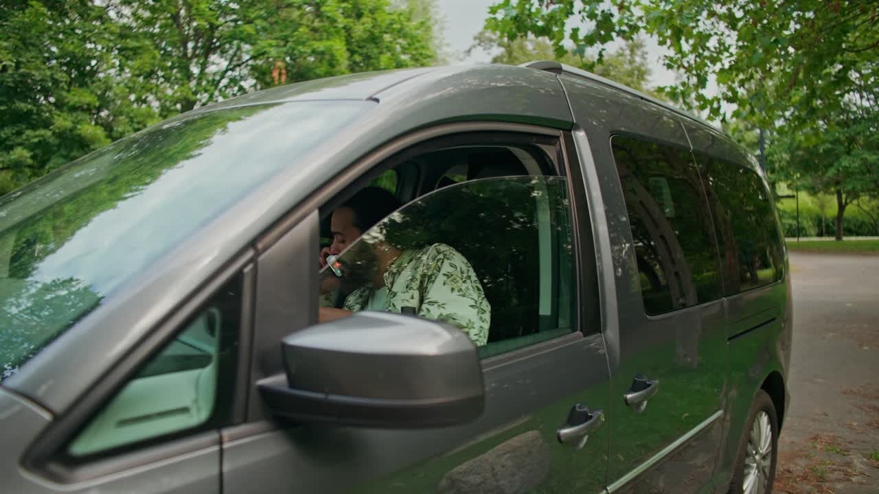 Uomo che sale su un minivan grigio