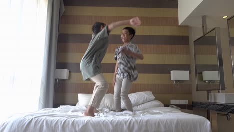 young childrens playing on the bed. boys having fun in the morning by jumping on bed