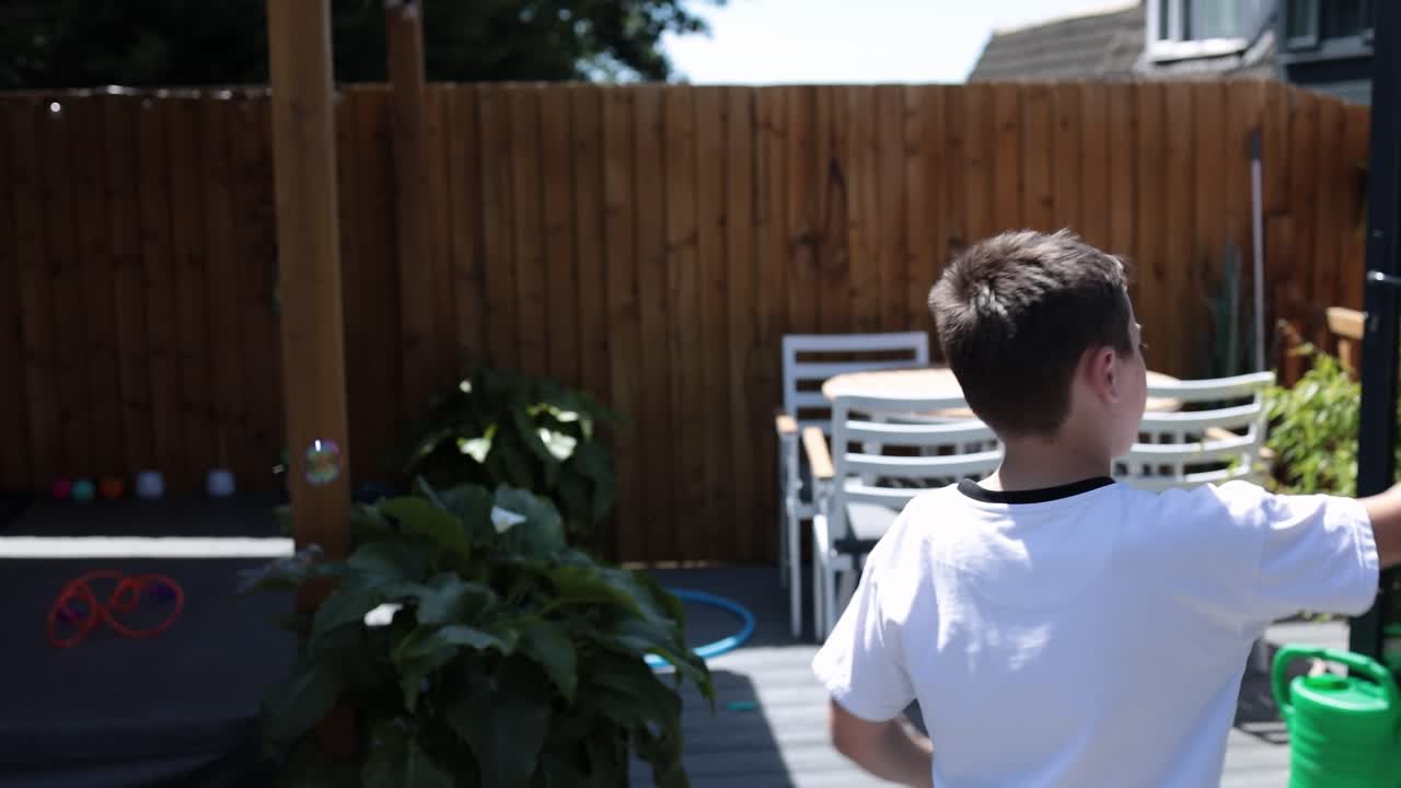 행복한 소년, 태양 여름 햇살 배경으로 정원에서 거품을 가지고 노는 아이