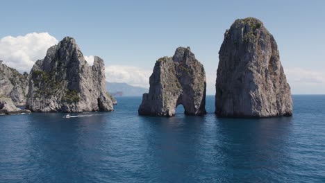 rock natural archway of the capri faraglioni sea stacks in italy - aerial