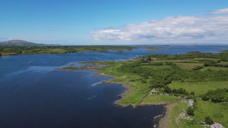 aerial view overflying the irish sea in the shore of galway bay during a sunny summer day - dunguaire castle in kinvarra, co. galway