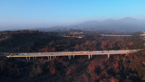 aerial push in shot to a bridge at sunset in a suburban city