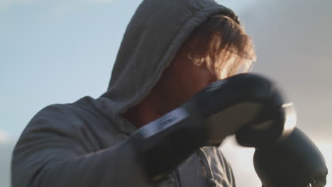 man boxing in the park in the evening sun in slow motion