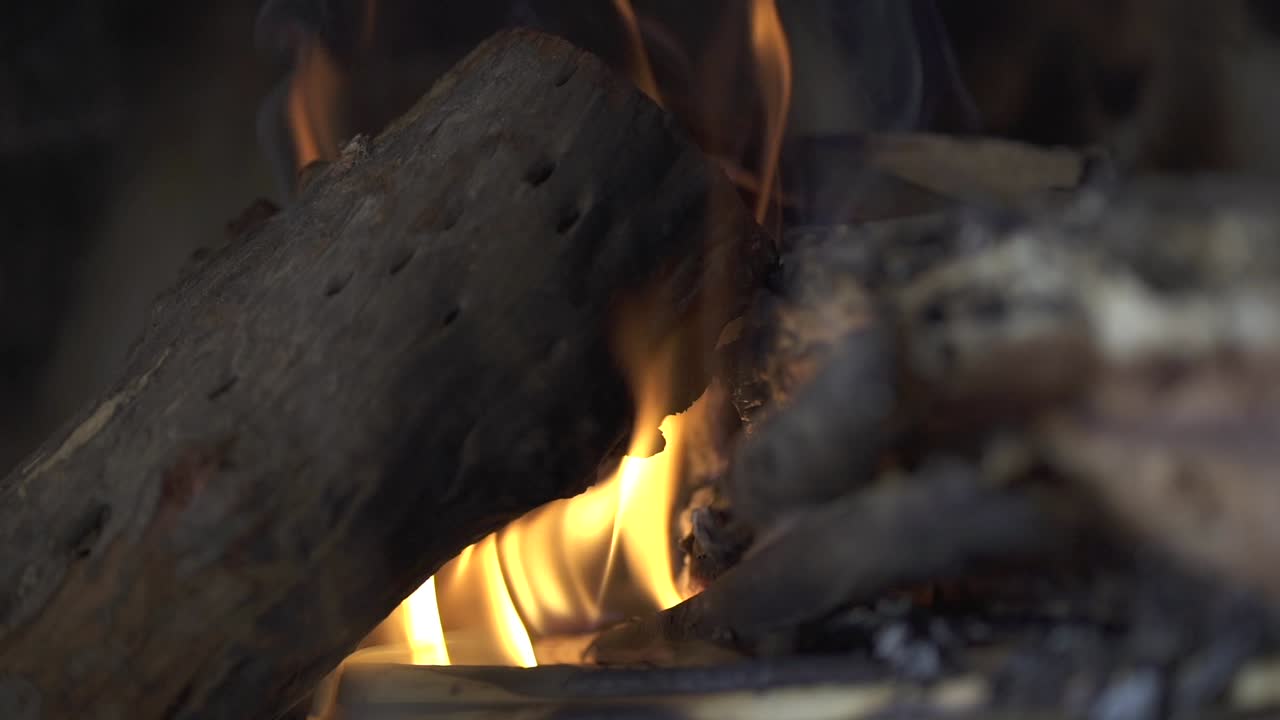 Close-up of the flames of a campfire burning between stacked wooden logs. Cozy home. Argentina.