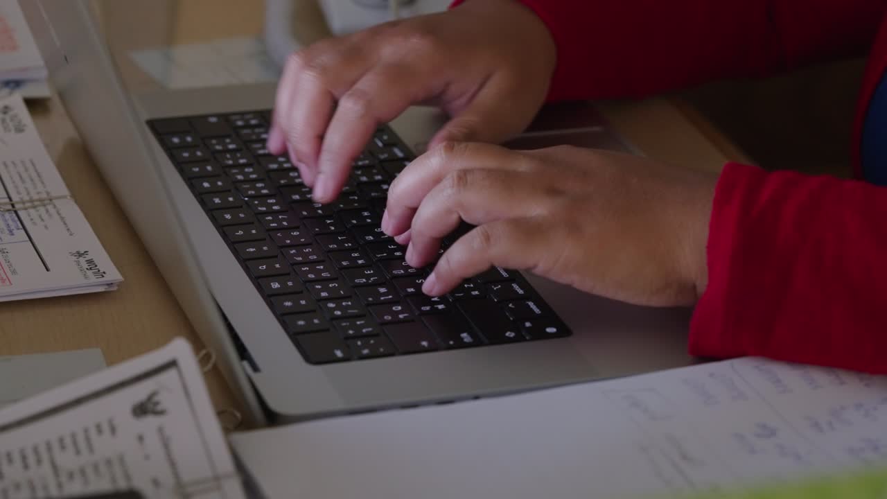 cerrar las manos de una mujer de negocios escribiendo investigación en la palabra clave de la computadora portátil e hizo un informe de negocios en el escritorio de la oficina por la noche.