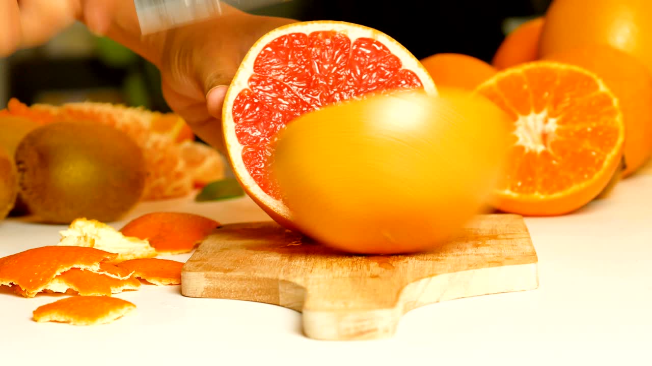 여성의 손은 칼을 사용하여 그레이프프루트를 잘라