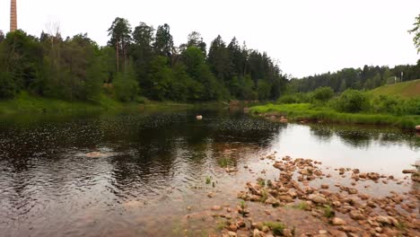 Fly-over-view-of-a-shallow-river-with-a-rock-bottom-in-Latvia