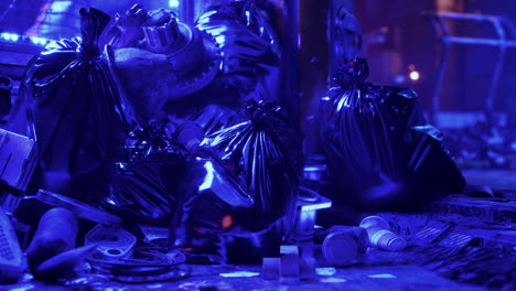 a pile of trash bags and debris illuminated by a blue light