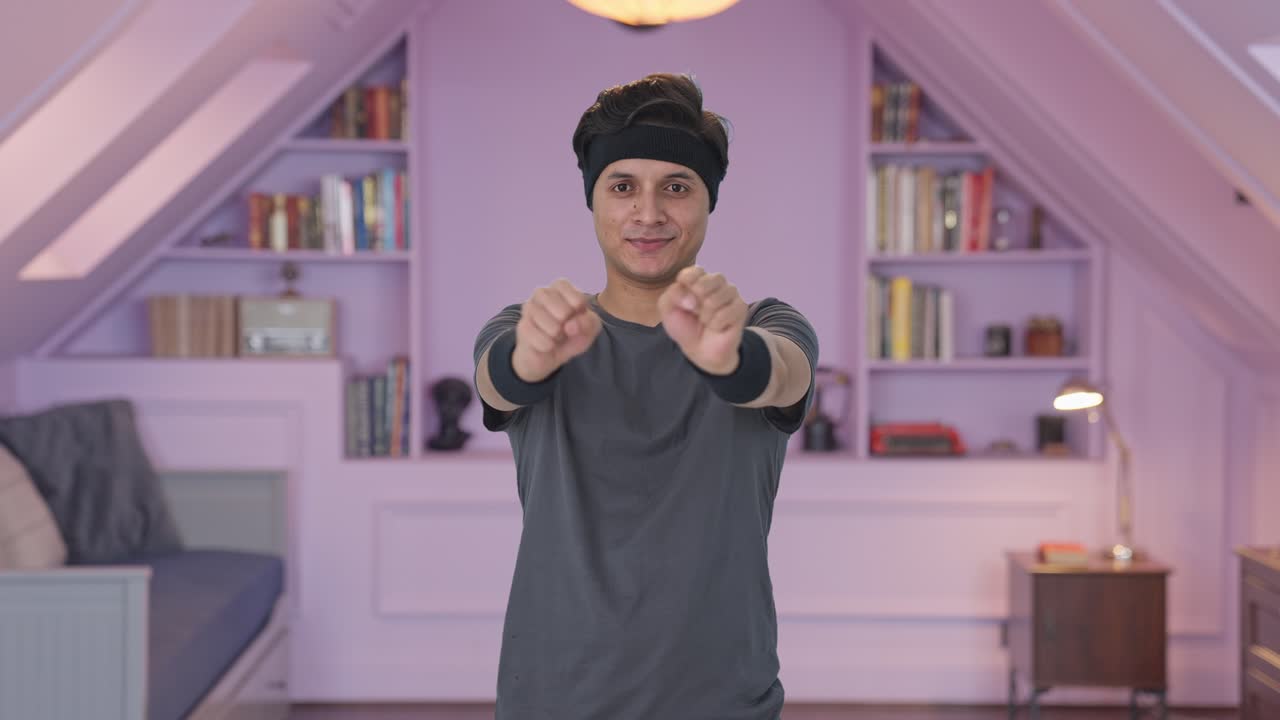 hombre indio feliz haciendo ejercicio de rotación de la muñeca