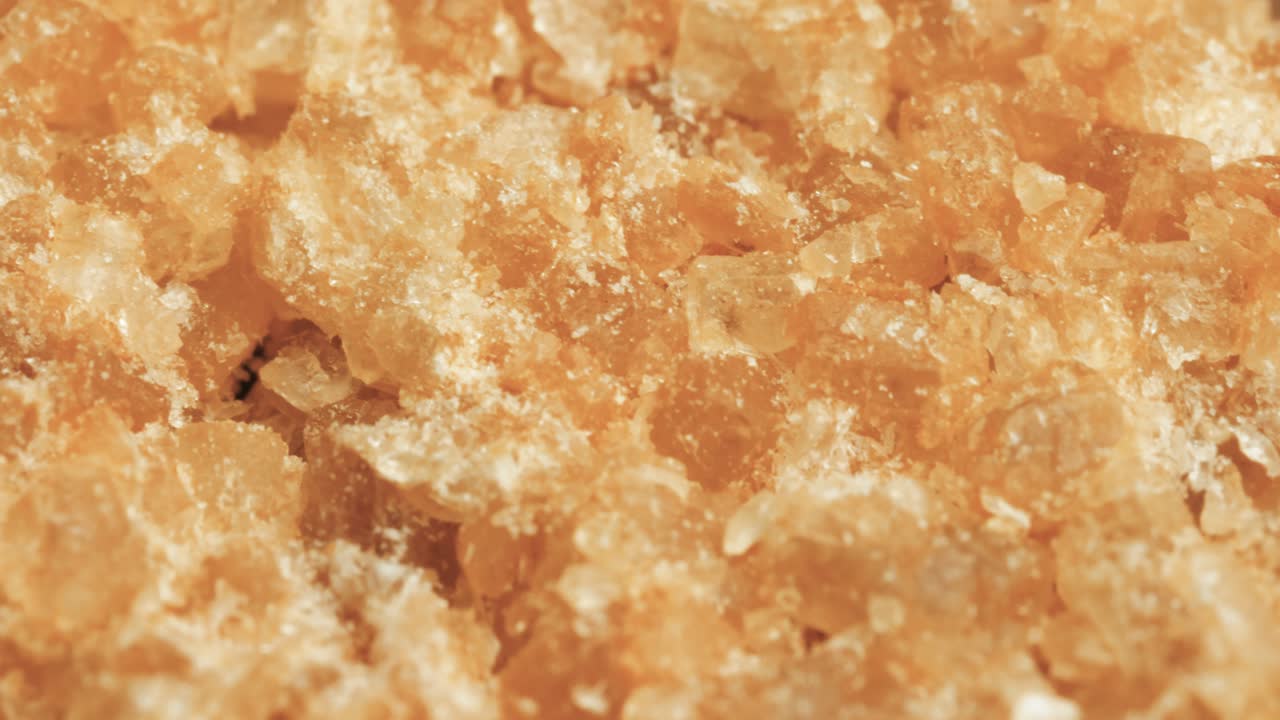 슈퍼 매크로 클로즈업 부분적으로 정제 된 부드러운 설탕 (자연 브라운 설탕) 은 약간의 잔류 멜라스 함유량을 가진 설탕 결정으로 구성됩니다.