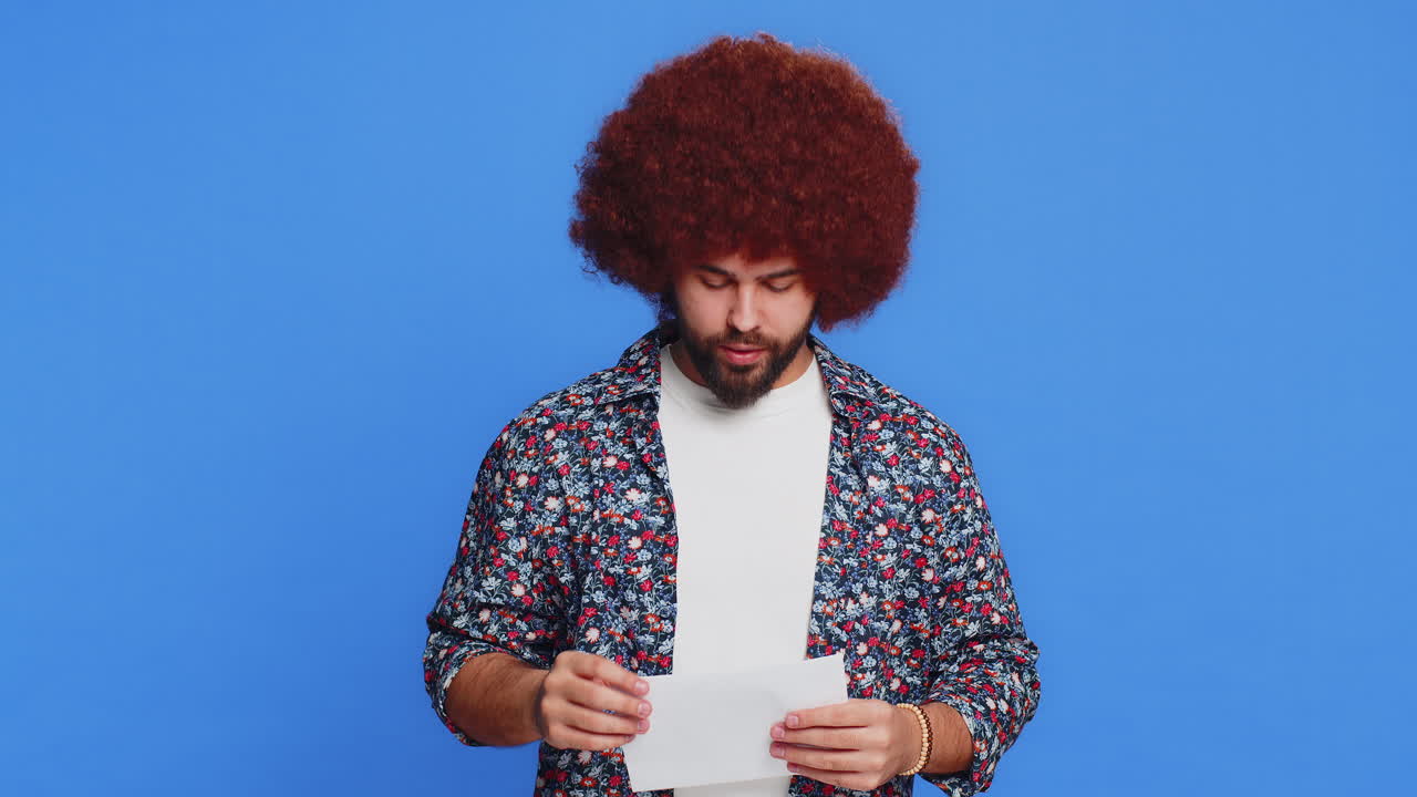 Un uomo felice e elegante apre una busta, tira fuori una lettera, legge un prestito bancario, approva una grande notizia, vince un premio.