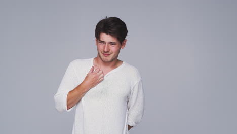 Wide-Angle-Studio-Shot-Of-Unhappy-Man-Looking-At-Camera-With-Sad-Expression-In-Slow-Motion