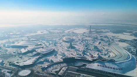 wide drone shot of the harbin ice festival 2025, showcasing vast ice sculptures, snowy landscapes, and an amusement park under a crisp winter sky. china