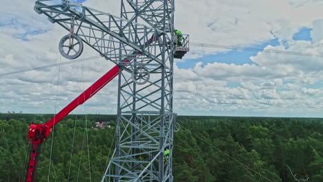 drone flying close to high voltage pylon while maintenance workers work in rural landscape