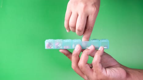 person filling a daily pill organizer with medication