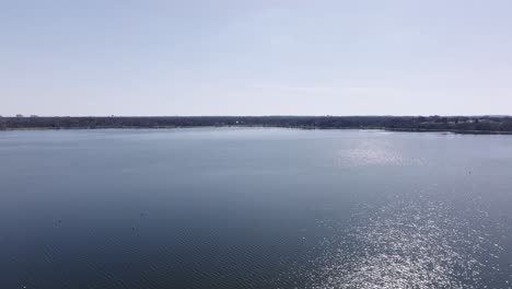 rotating aerial drone shot of a lake on a bright sunny day