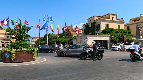 motorbikes and cars navigate a bustling roundabout