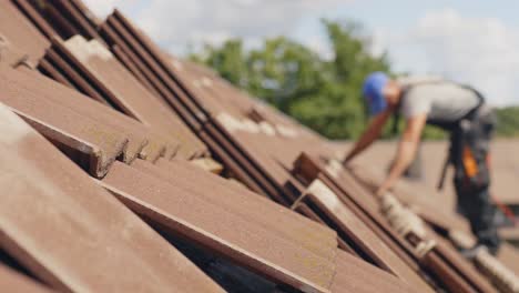 Instalación-De-Paneles-Solares,-Techador-Trabajador-Borroso,-Foco-En-Tejas,-Día