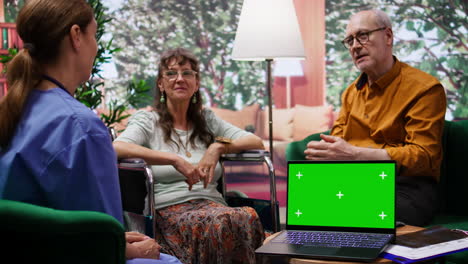 Nurse-discussing-with-elderly-people-at-their-home-next-to-isolated-chroma-key