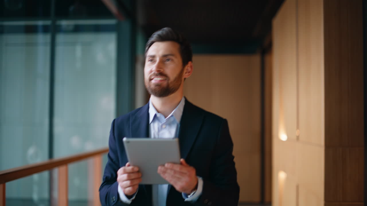 Entrepreneur browsing tablet walking hallway office closeup. Smiling businessman