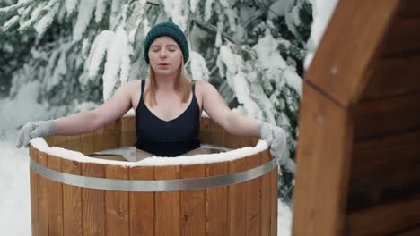 une femme caucasienne prend un bain d'hiver dans de l'eau gelée.