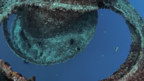 unique view of a scuba diver swimming through a large underwater structure created as an artificial reef