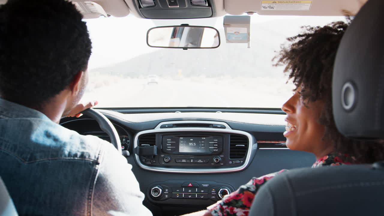 Happy young black couple driving car, back view, close up