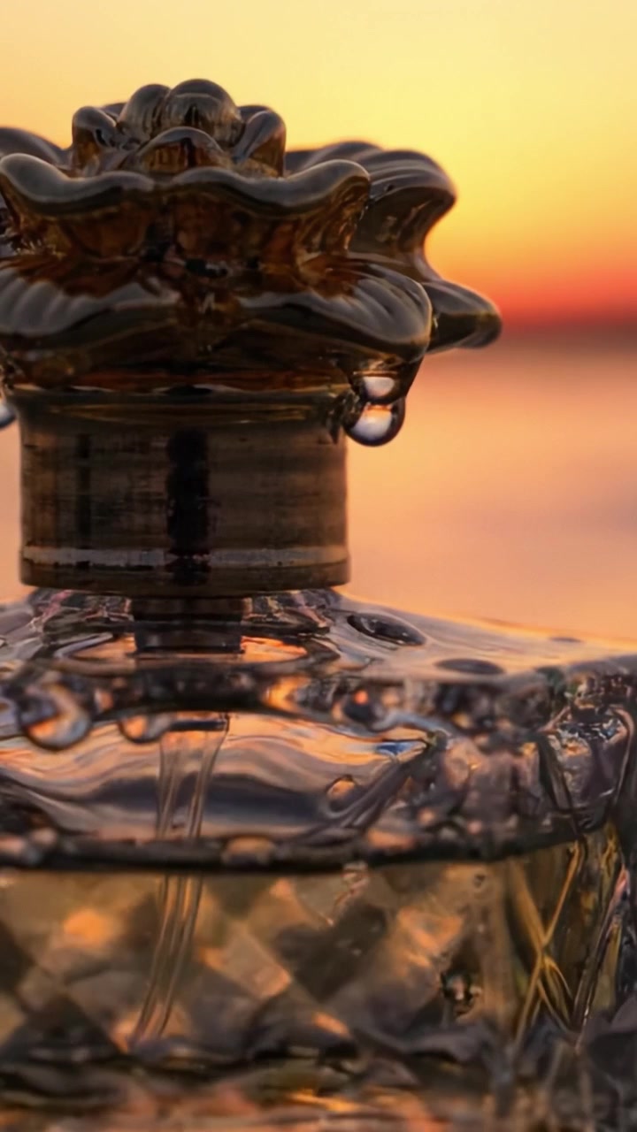 Un Primo Piano Accattivante di una Bottiglia Decorativa Contro un Tramonto Vivace, con Goccioline d'Acqua Scintillanti e Riflessi Sottili su uno Sfondo Naturale Sfocato