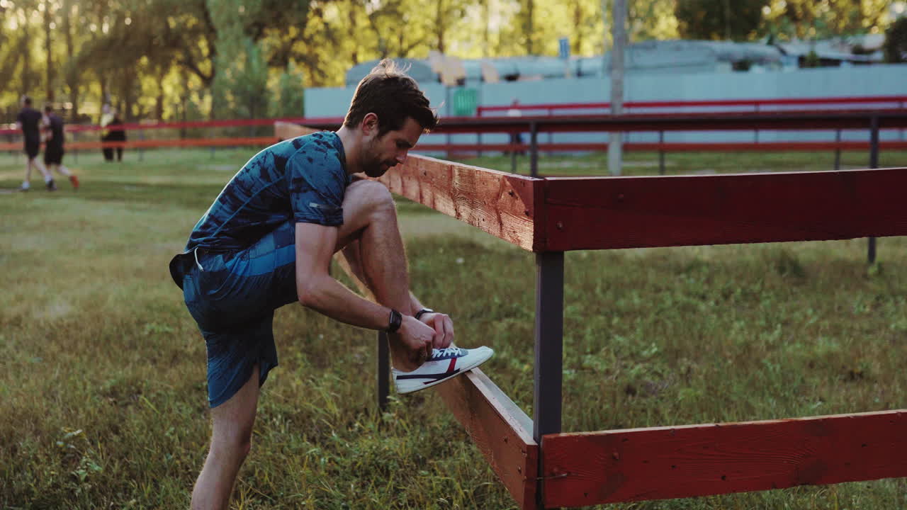 hombre atando sus zapatos antes de una carrera en un parque