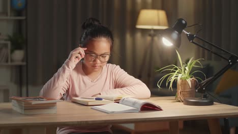 teenage girl sleepy from doing home work at night