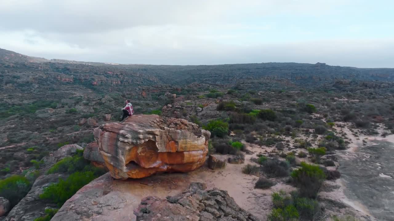 человек сидит на скале 4k