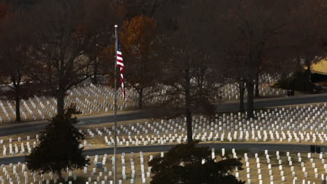 American-flag-on-pole-in-middle-of-cemetery-memorial-in-Fayetteville,-rising-aerial