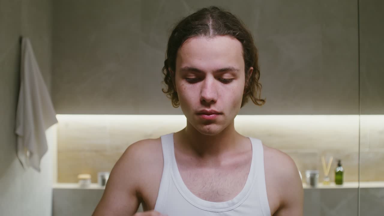 hombre cepillándose los dientes en el baño