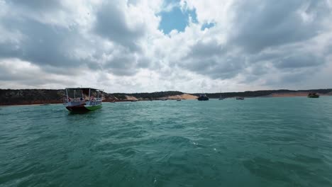 Action-Kameraaufnahme-Auf-Einem-Kleinen-Fischerboot,-Das-An-Angedockten-Booten-Am-Cacimba-Strand-In-Der-Berühmten-Surfstrandstadt-Baia-Formosa-In-Rio-Grande-Do-Norte,-Brasilien,-An-Einem-Warmen,-Sonnigen-Sommertag-Vorbeisegelt