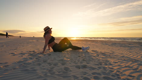 static shot of caucasian woman sitting on a sandy beach with two dogs playing around, outdoor