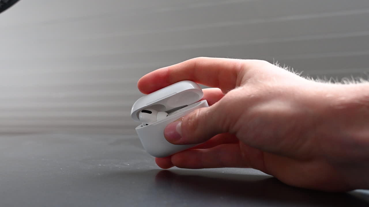 Un giovane appassionato di musica chiude una piccola scatola bianca contenente auricolari dopo l'intrattenimento