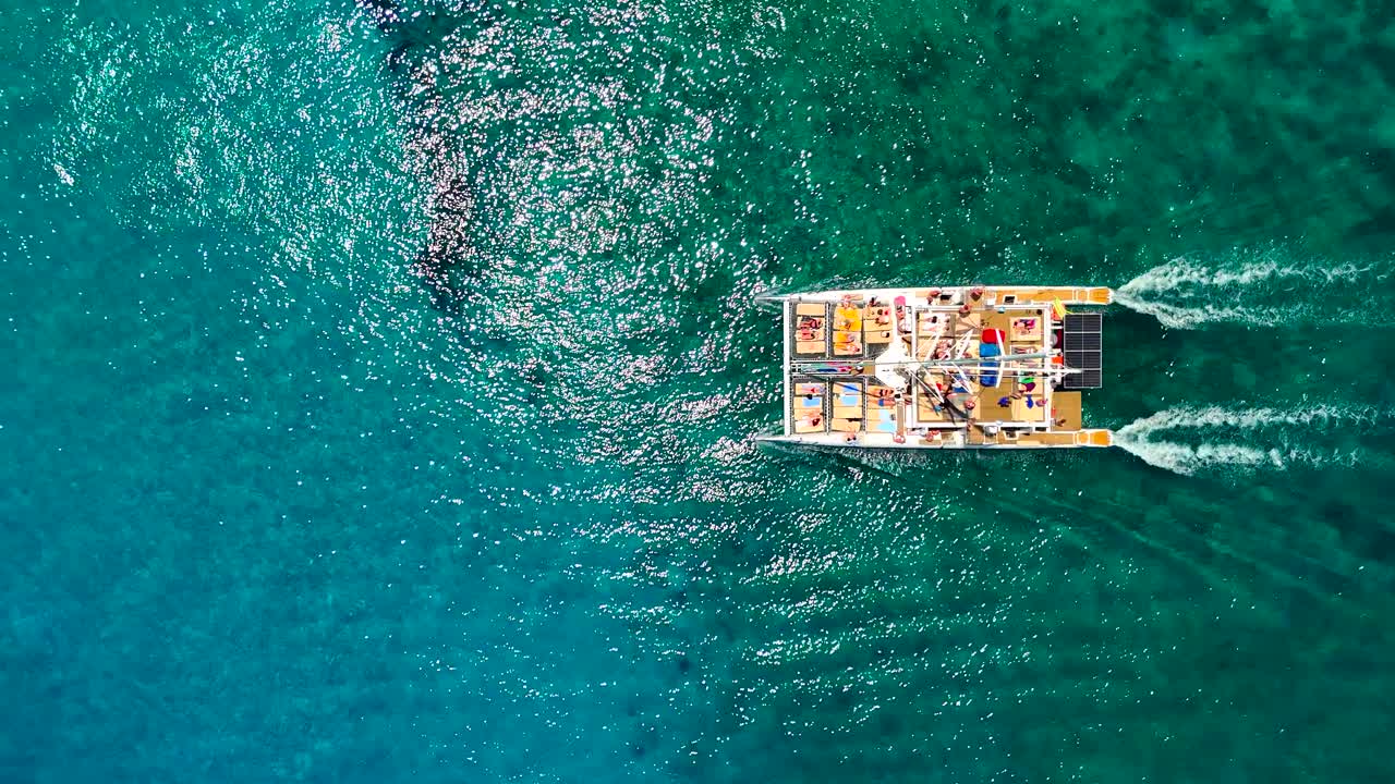 Enjoy the majestic sight of a colorful boat cutting through sparkling blue waters. Experience the joy of sailing among breathtaking ocean views and perfect weather
