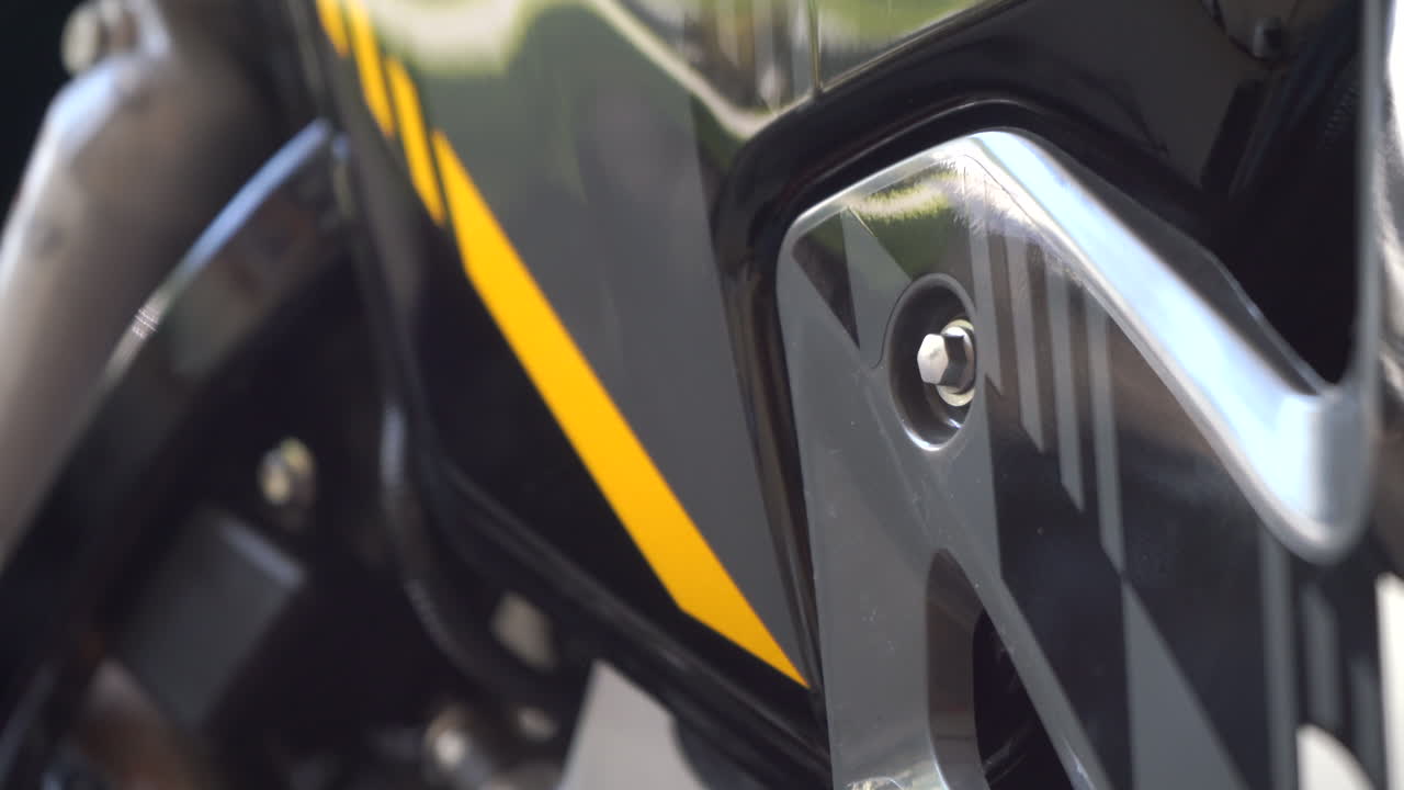 오토바이의 바디에 있는 운전자와 함께 볼트 헤드를 단단히 는 메카닉의 손 - 가까운 초점 손에서 볼트 헤드로 끌어