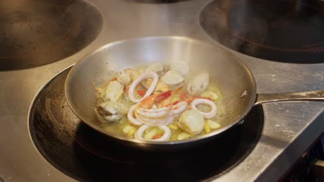 Stir-fry-onion-in-olive-oil-with-seafood,-preparition-of-Mediterranean-soup