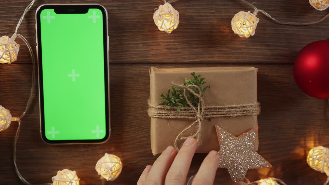 diy 포장 크리스마스 선물 포장 스마트 폰 나무 테이블에 녹색 화면