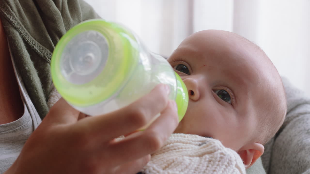 madre joven alimentando al bebé bebiendo de la botella de leche madre amorosa cuidando del bebé disfrutando de la maternidad