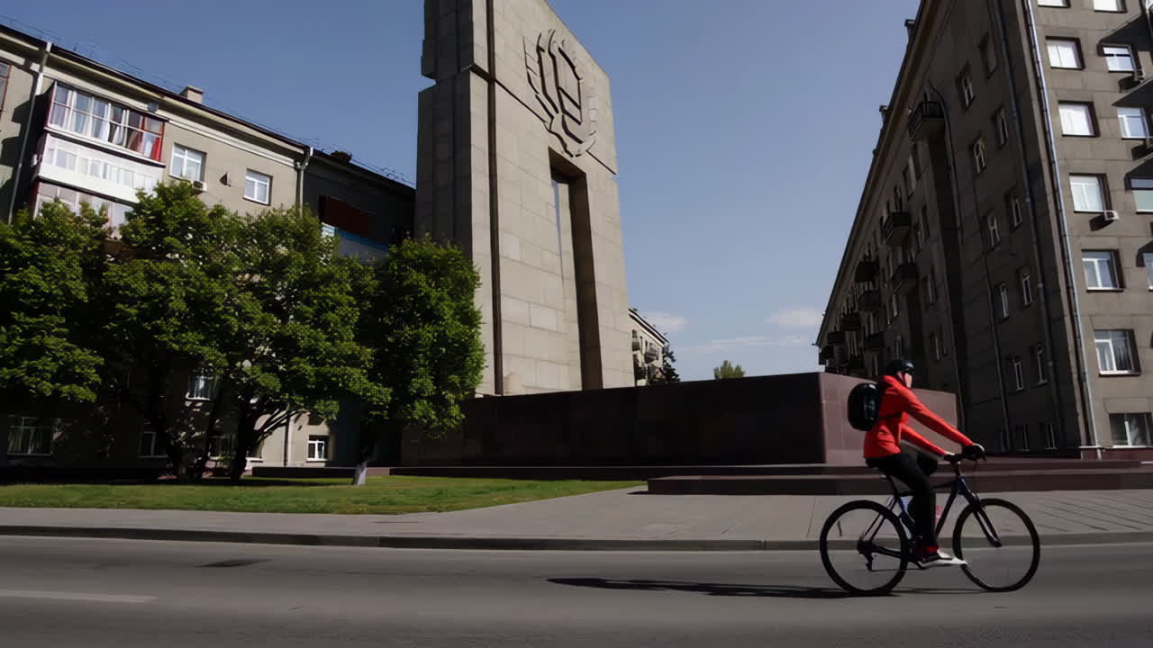 Cyclist near a monument in a city street