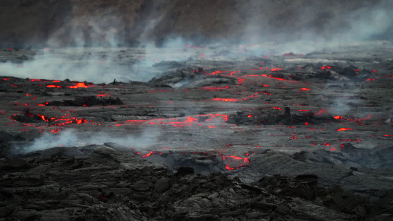 연기와 함께 용암 밭에 흐르는 붉은 오렌지 녹은 용암