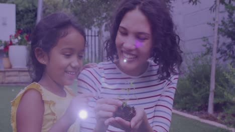 mancha de luz contra madre y hija asiáticas tocando muestras de plantas en el jardín