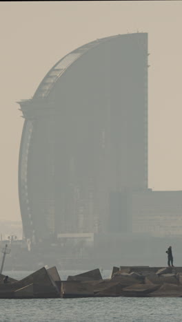 barcelona, spain - 31 august 2024 : barcelona beach and coastline with the buildings in shadow in late afternoon in vertical.