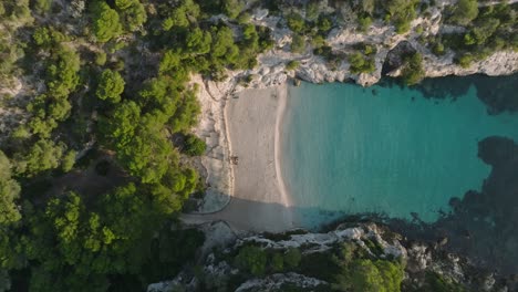 Stunning-flyover-of-turquoise-waters-at-Macarelleta-virgin-beach,-Menorca