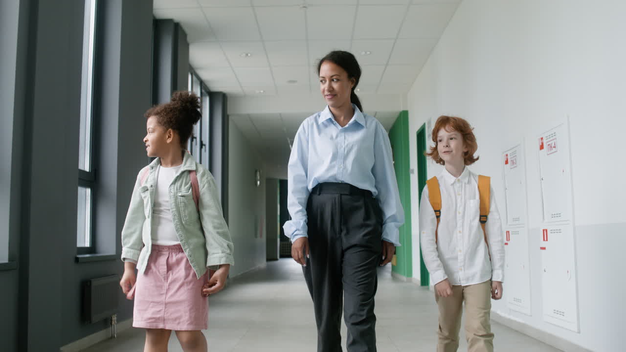 Teacher and pupils walking through the corridor.